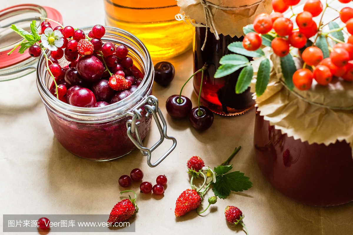 水果蜜饯和生草莓,樱桃,花楸浆果摆在桌上